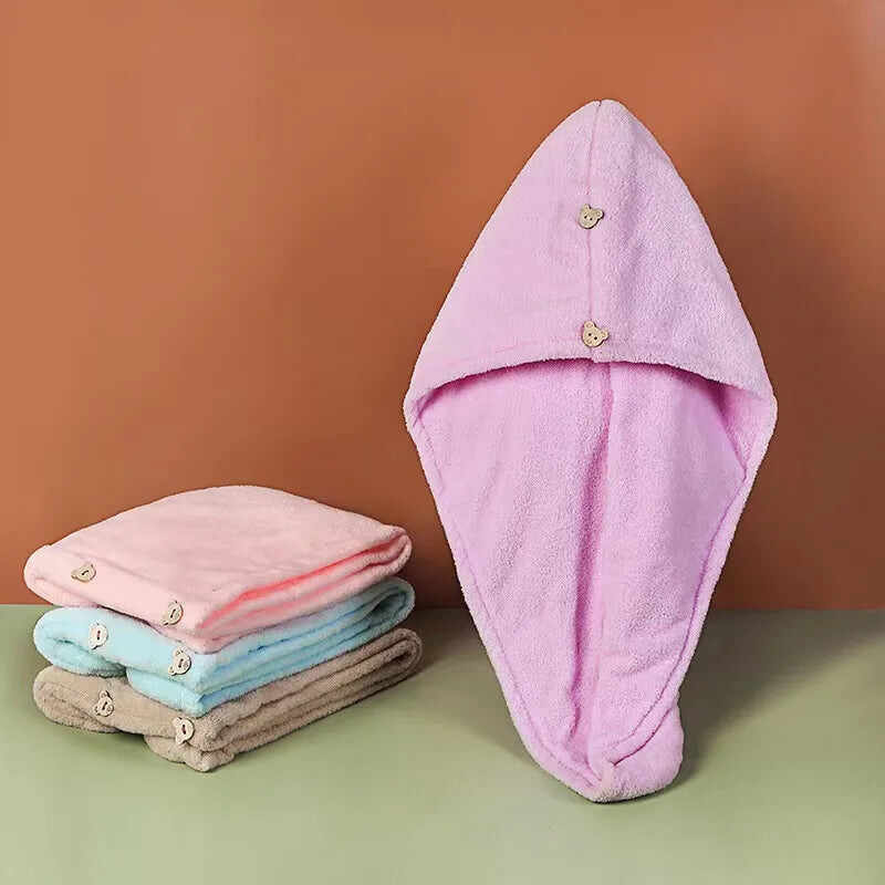 Quick dry microfiber hair towels in assorted colors stacked with a pink towel featuring button closure